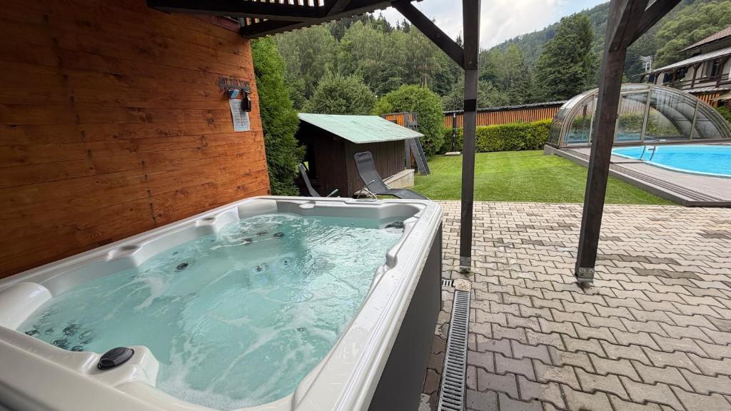a jacuzzi tub in a backyard with a pool at CHATA POD HORAMA in Benecko