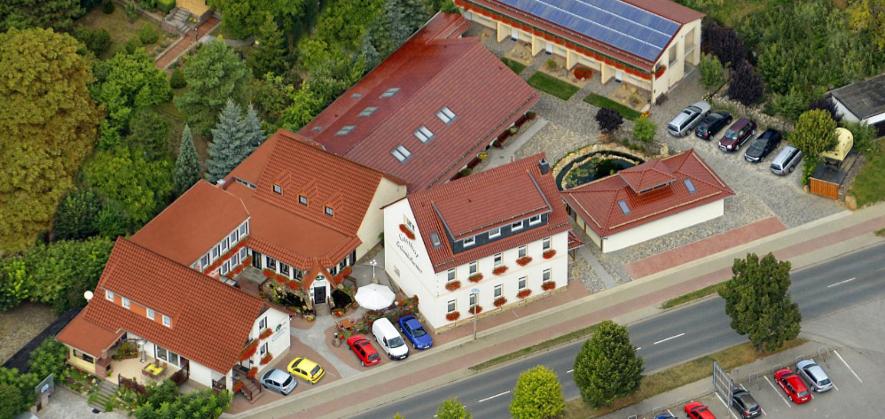 a large building with cars parked in front of it at Gasthof Schondelmaier in Oschersleben