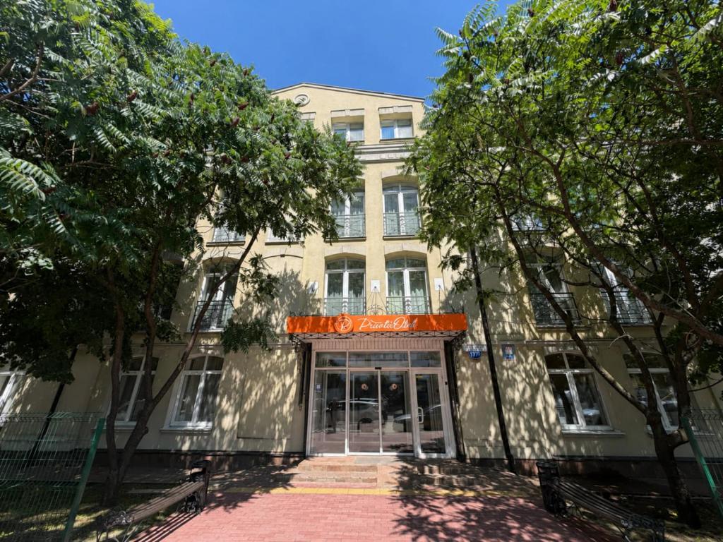 a building with the front of it with trees at PracticOtel Kyiv in Kyiv