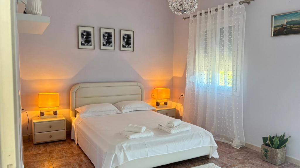 a bedroom with a white bed and two lamps at Folini House in Magaziá