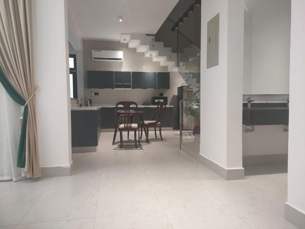 a kitchen with chairs and a table in it at Alpha Holiday Home in Barka
