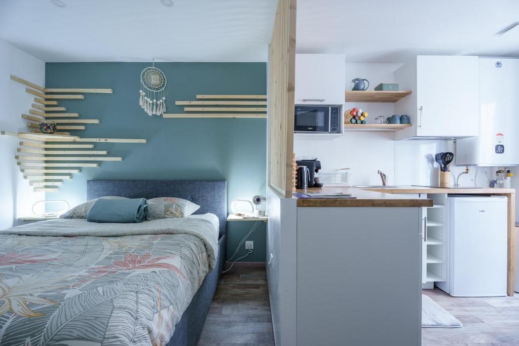 a small bedroom with a bed and a kitchen at Studio cosy Allevard in Allevard