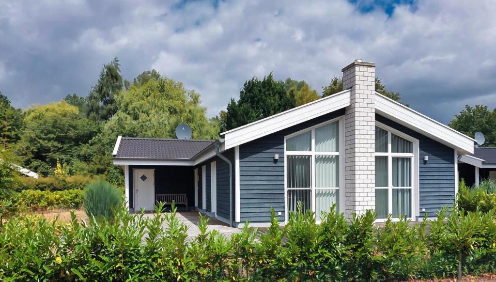a blue and white house with trees in the background at Carpe Diem - Nordhorn in Nordhorn
