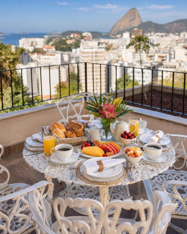 a table with breakfast food on a balcony at New Sugar Loft Apartments in Rio de Janeiro