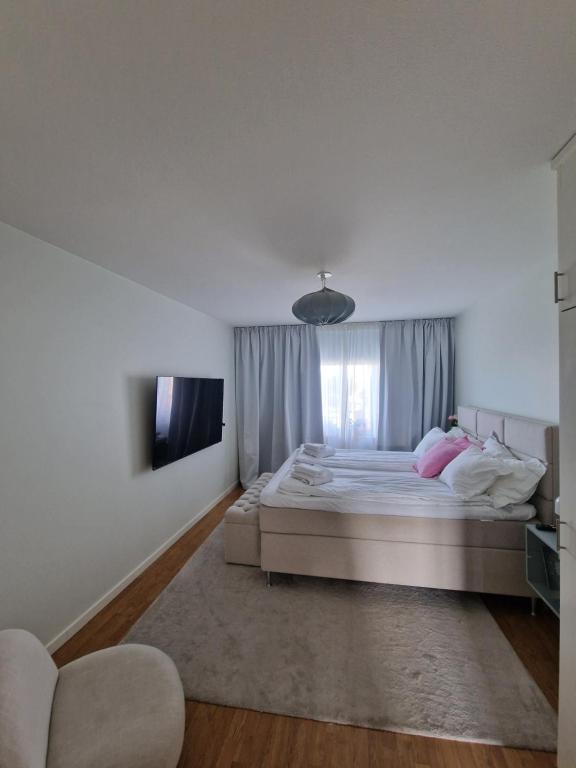 a white bedroom with a bed and a window at Central lägenhet i Visby -4 person inkl parkering in VBY