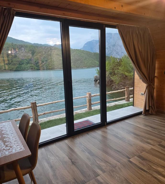 a room with a large window with a view of a lake at Mrizi i Drinit in Arrëz