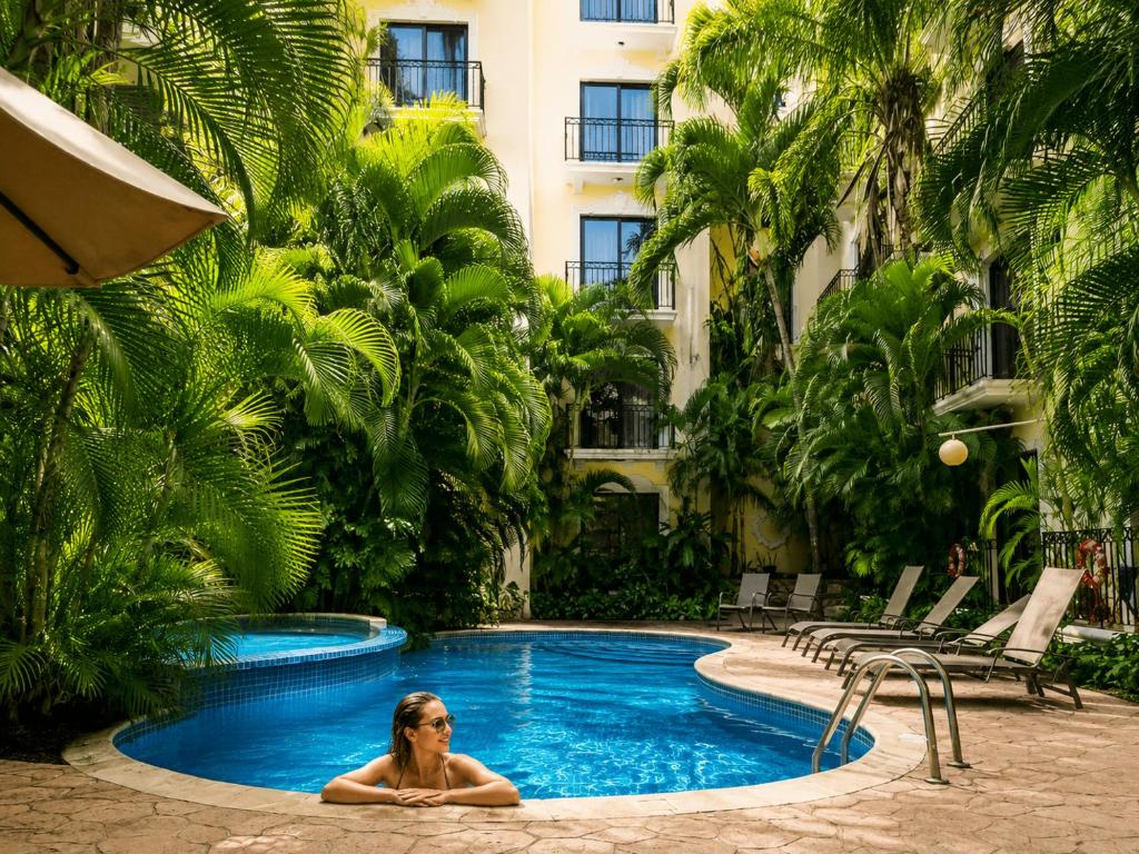 a woman sitting in a pool in a hotel at Gran Real Yucatan in Mérida