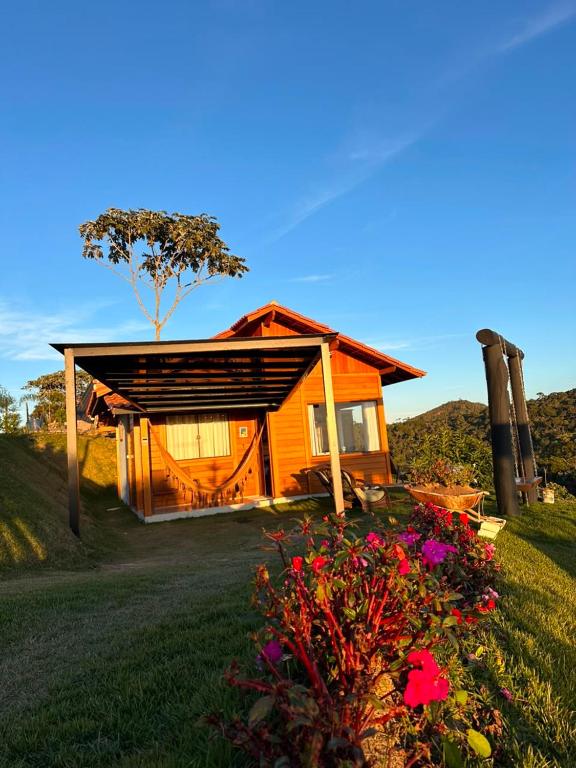 a small house with flowers in front of it at Chalé dos Manacás 02 Venda Nova Alto Colina ES in Venda Nova do Imigrante