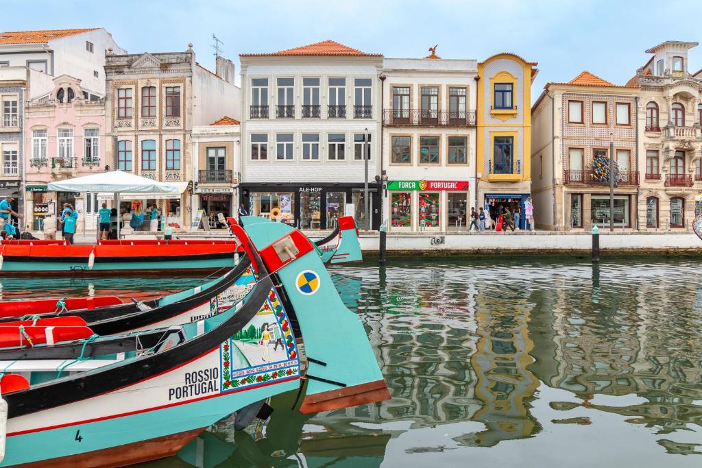 ein Boot, das vor Gebäuden im Wasser liegt in der Unterkunft SAL Collection Hotel in Aveiro