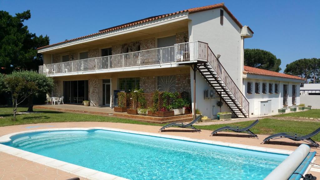 a house with a swimming pool in front of a house at Chambres d'hôtes et gîtes Al Pati in Sorède