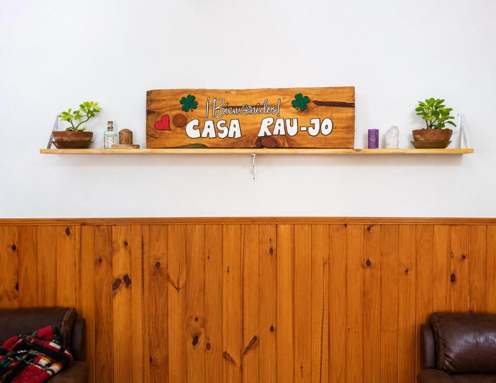a wooden shelf on a wall with two chairs at Casa RAU-JO in Guaymallen