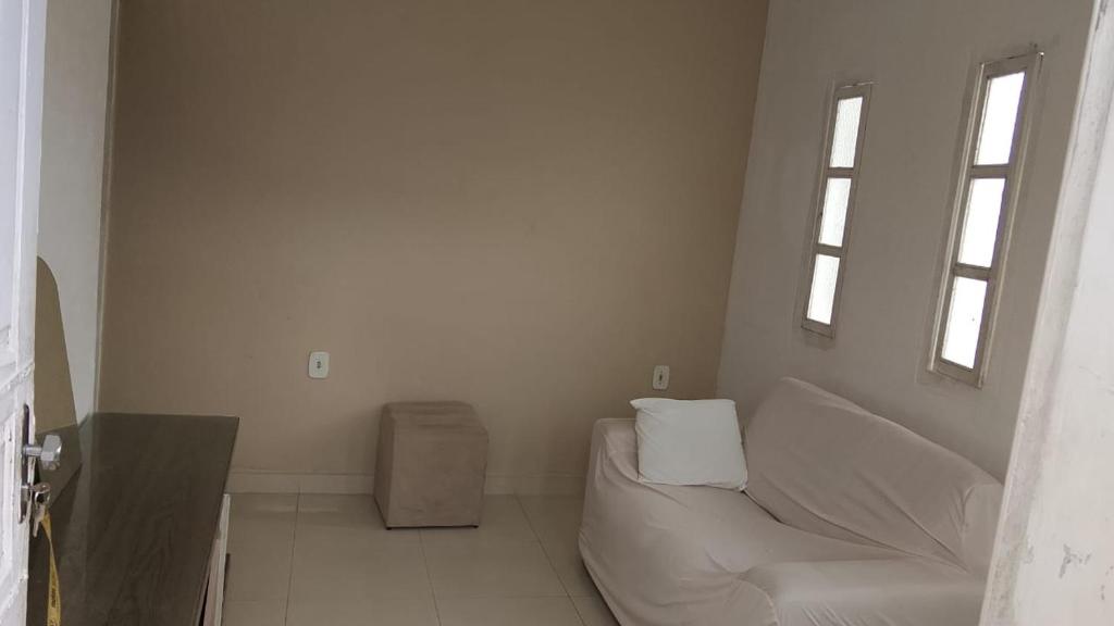 a living room with a white couch and a window at Jabutiana casas Mobiliadas in Aracaju