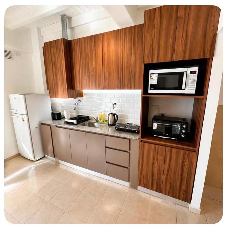 a small kitchen with a microwave and a refrigerator at Departamentos Centro in San Juan