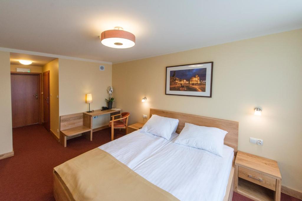 a bedroom with a bed and a desk in it at Hotel Gorzów in Gorzów Wielkopolski