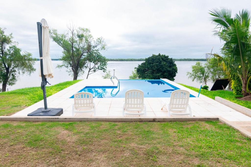 a swimming pool with chairs and the water at Habitacion en Cabañas Bella vista in Bella Vista