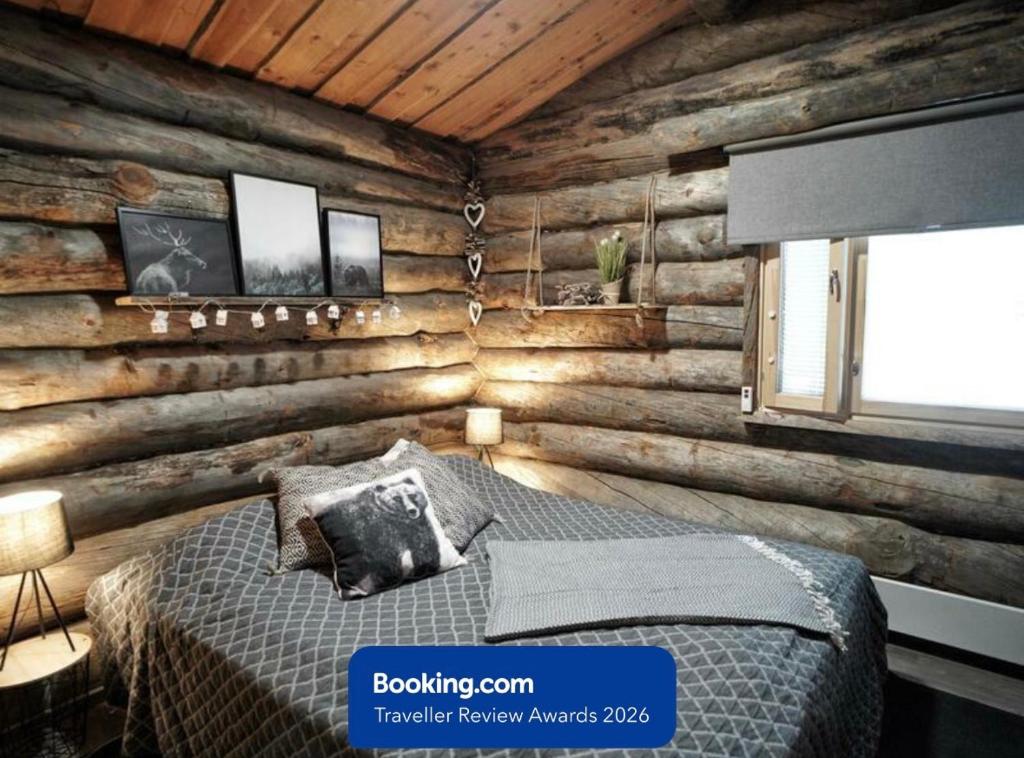 a bedroom with a bed in a wooden wall at RukaTupasvilla in Ruka