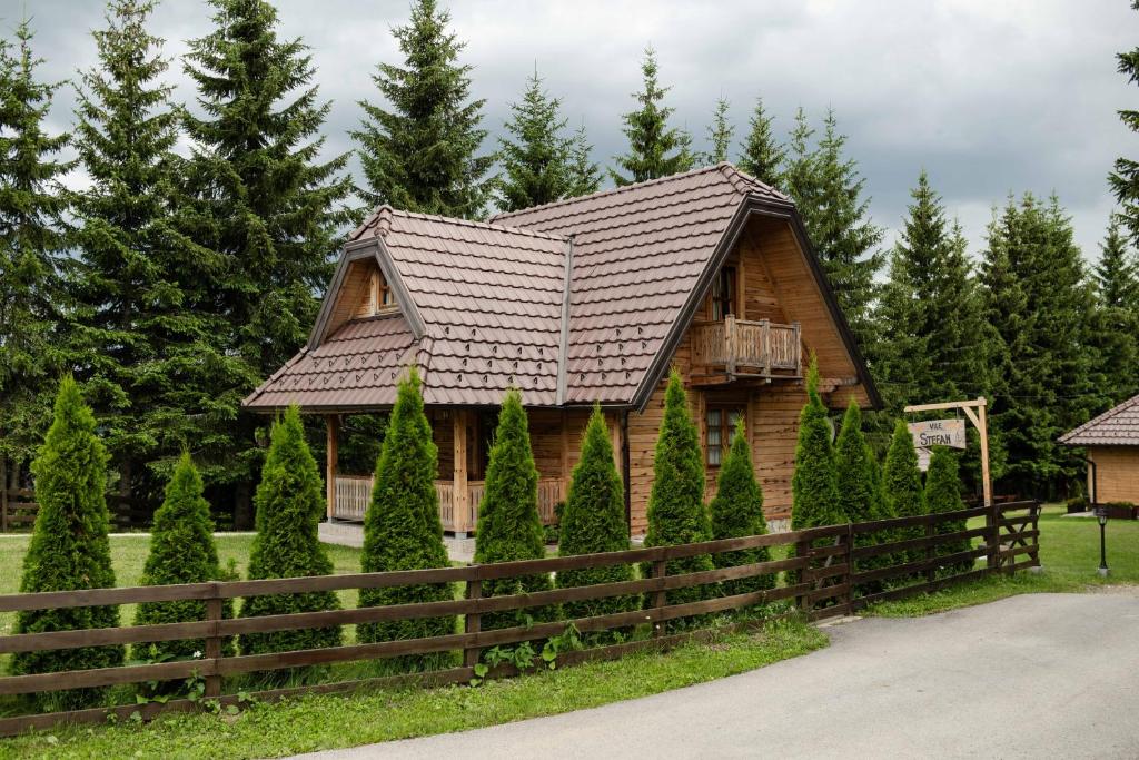 a log cabin with a fence and trees at Vile Stefan in Zaovine