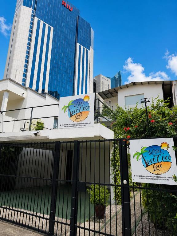 a fence in front of a building with signs on it at Hostal Loco Coco Loco in Panama City