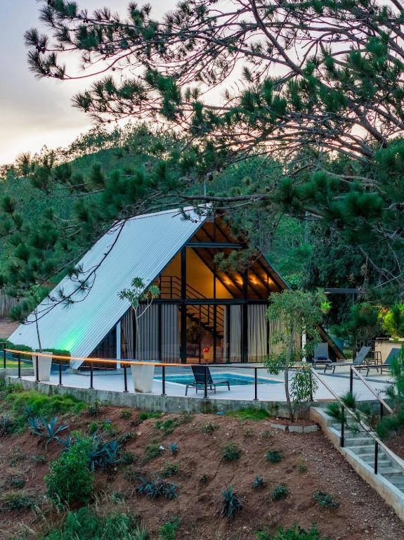 a house with a glass facade with a pool at Alpine River Cabin with direct access to the river in Río Arriba