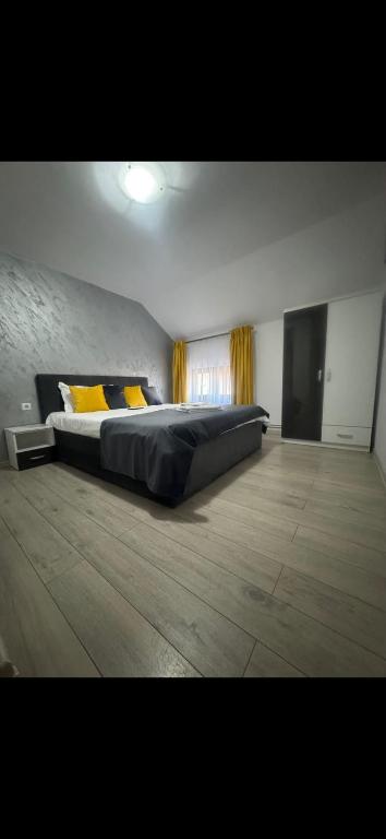 a bedroom with a large bed with yellow pillows at Sophia Maria Caciulata in Caciulata