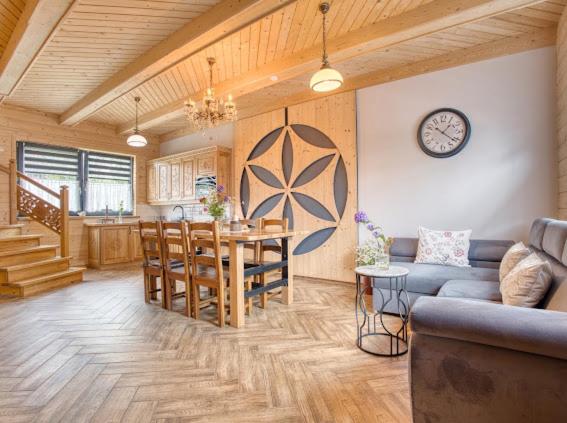 a kitchen and living room with a table and a dining room at Apartamenty Bąkowo Chatka in Witów