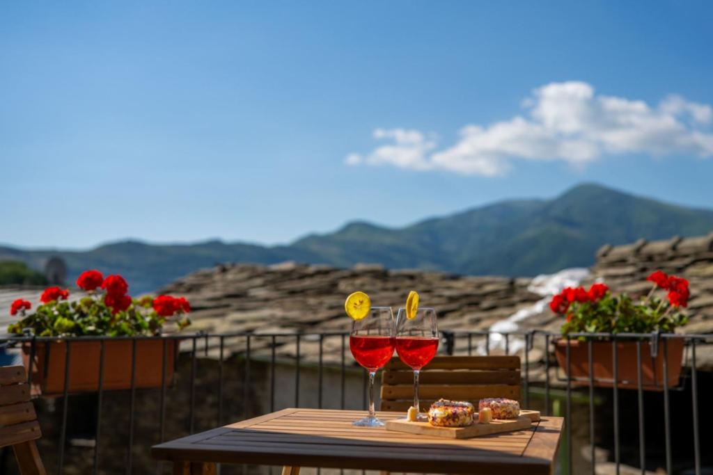 Zwei Gläser Rotwein stehen auf einem Tisch. in der Unterkunft I Sitoù in Ostana