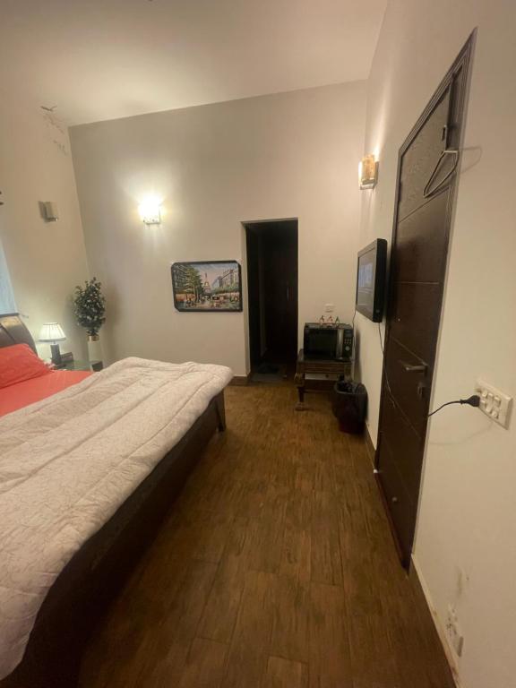 a bedroom with a large bed and a television at Executive Guest Room - Helcion Residency in Lahore