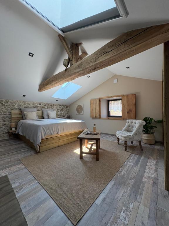 a bedroom with a large bed and a table at Chambre K-arole in Pouzauges