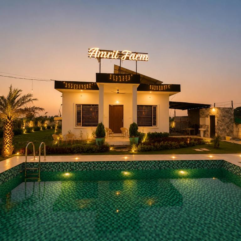 a house with a swimming pool in front of it at Amrit Farm in Rāi