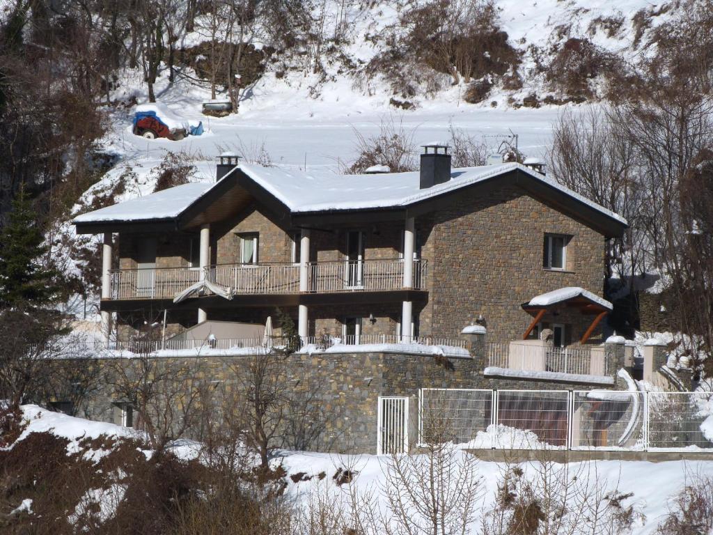 een huis met een met sneeuw bedekt dak in de sneeuw bij Xalet Marsal-Vacances Pirinenca in Encamp