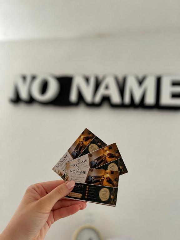 a person holding a card in front of a company sign at No name in Jajce