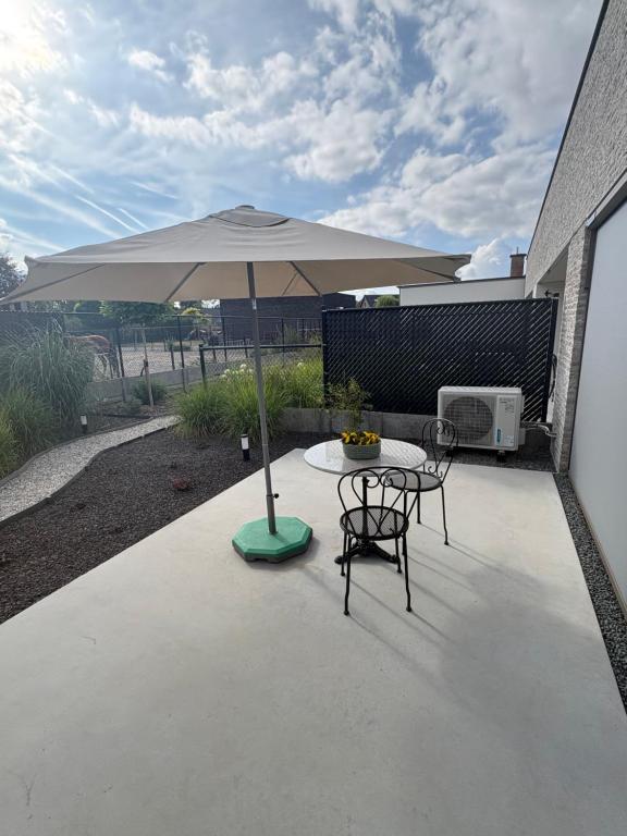 a patio with an umbrella and a table and chairs at Green HOME Wieze in Wieze
