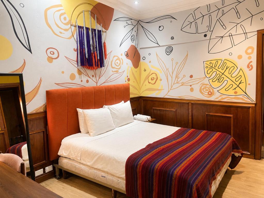a bedroom with a bed with a painting on the wall at Cavi Rooms 307 in Cuenca