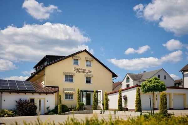 a large white building with solar panels in front of it at Schneider HOTEL & APARTMENTS ALLERSBERG in Allersberg