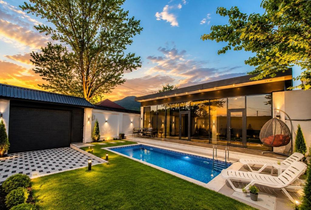 a backyard with a swimming pool and a house at Qafqaz Four Seasons in Gabala