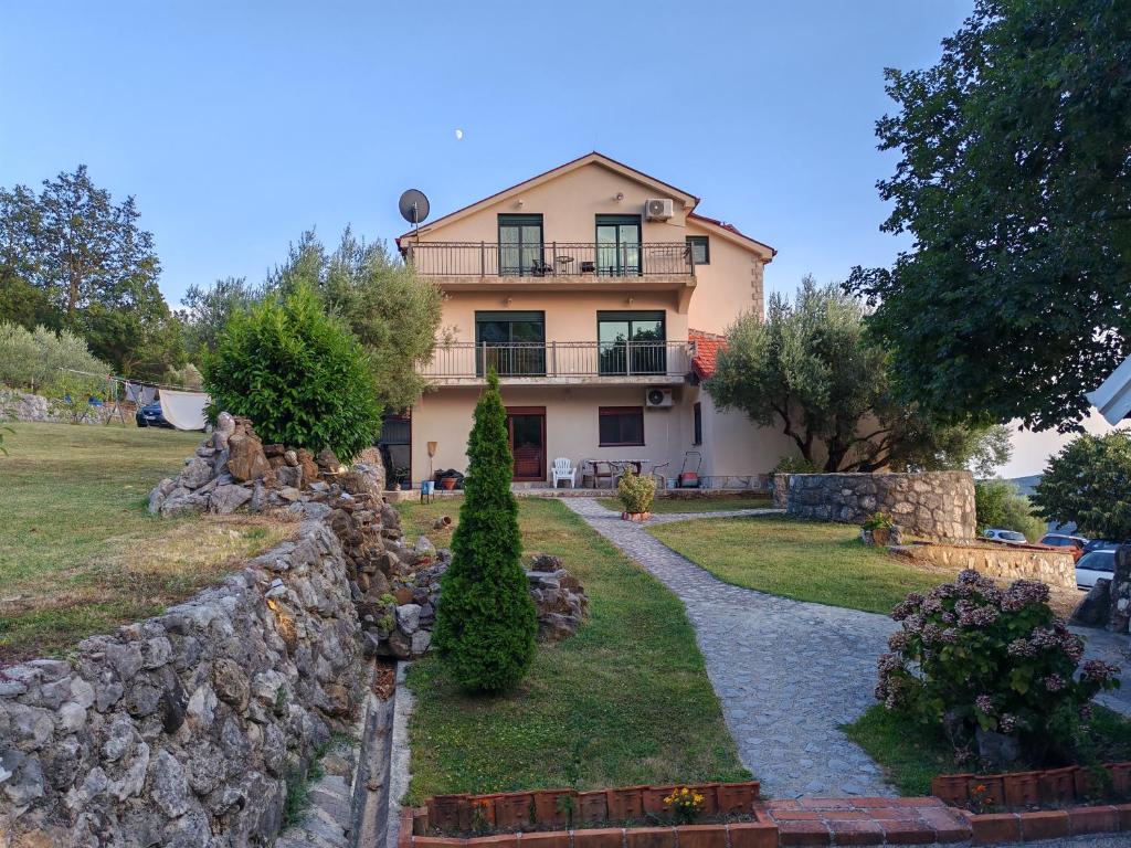 a house with a stone wall in front of it at Forest Apartments in Kotor