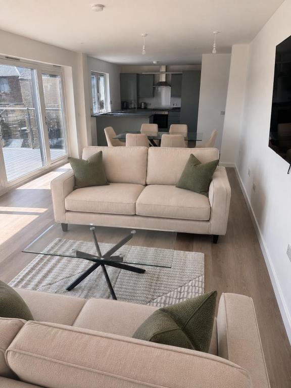 a living room with two couches and a kitchen at Dalhousie Residences in Carnoustie