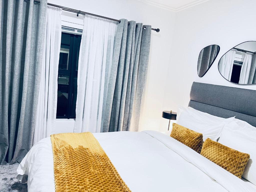 a bedroom with a white bed and a window at The cozy garden suites in Sandton