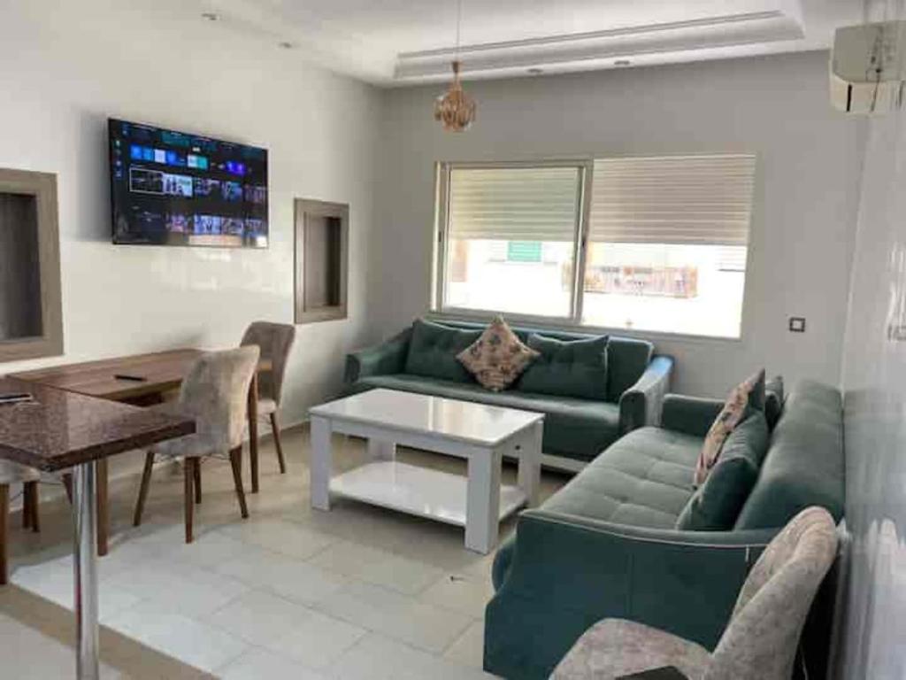 a living room with a green couch and a table at Suite Horizon in Mohammedia
