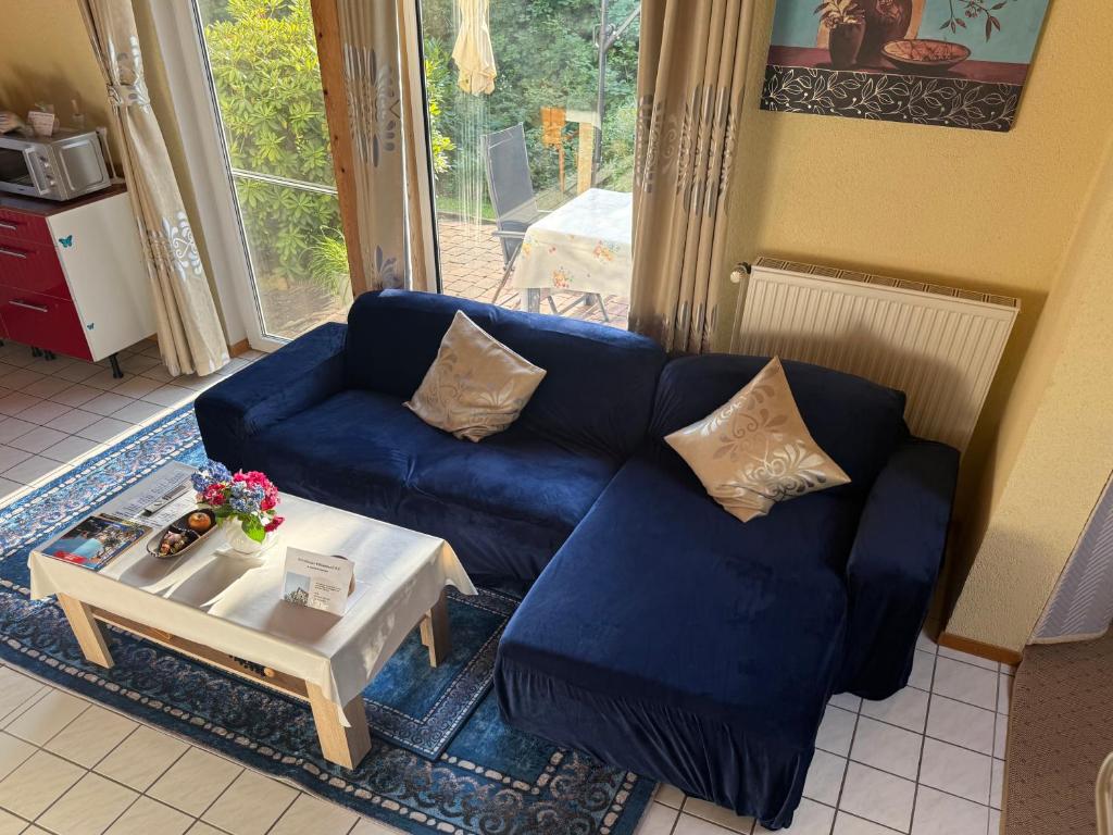 a living room with a blue couch and a coffee table at Ruhiges Elbhäuschen nahe Hamburg in Hollern-Twielenfleth
