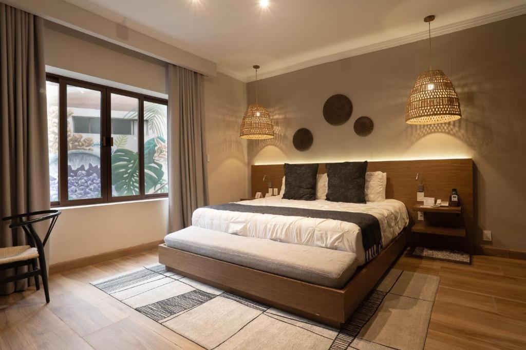 a bedroom with a bed and two chandeliers at Agata Hotel Boutique & Spa in Mexico City