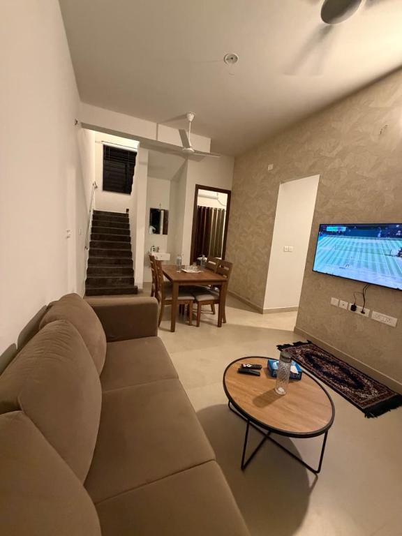 a living room with a couch and a flat screen tv at coastal coral in Tirupporūr