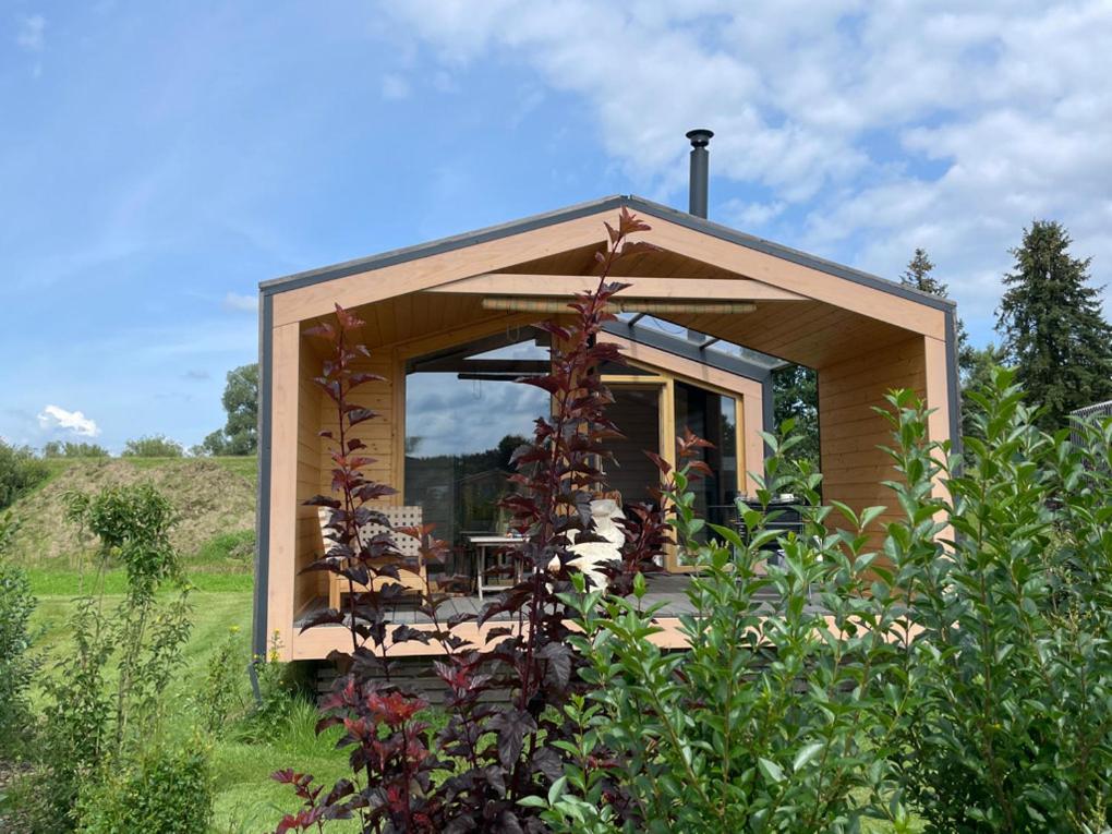 a tiny house with a large window in a field at 302 Charmantes naturnahes Tiny House- das Herman in Bleckede