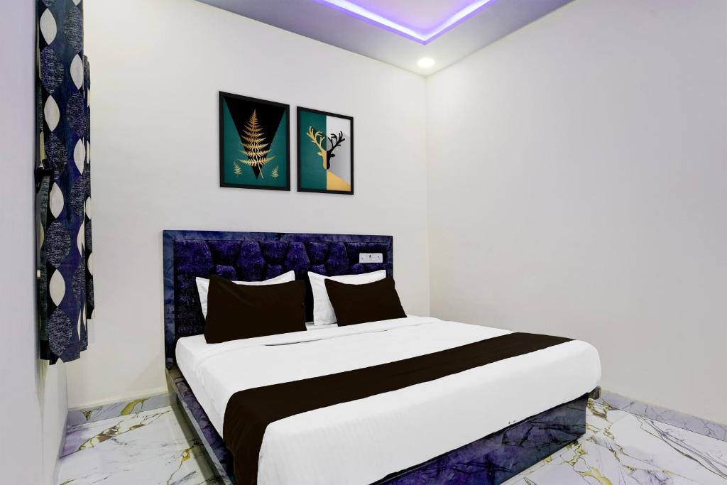 a bedroom with a king sized bed with a blue headboard at SPOT O SKY LINE in Chandrapur