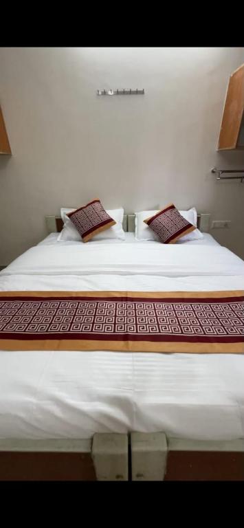 a bedroom with a large bed with white sheets and pillows at Vp residency in Bangalore