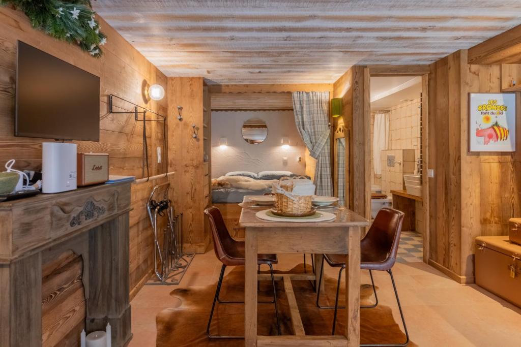 a dining room with a table and chairs and a bedroom at Les Évouettes Châtel village in Châtel