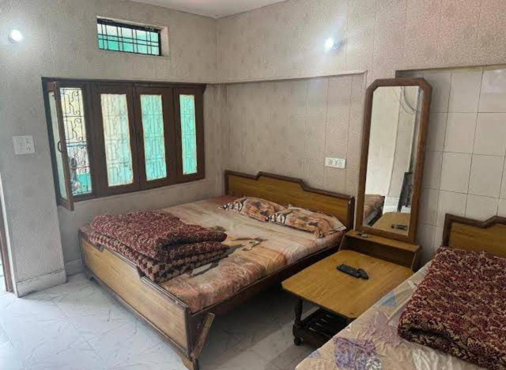 a bedroom with a large bed and a mirror at Hotel Sunil Lodge in Gaurikund