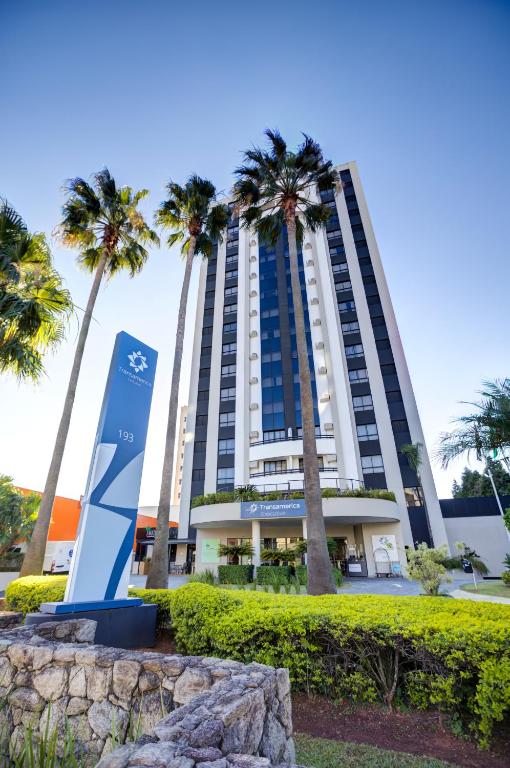 a tall building with palm trees in front of it at Transamerica Executive Sorocaba in Sorocaba