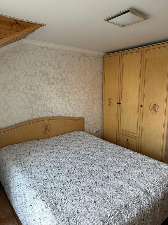 a bedroom with a bed and a cabinet at Колиска Карпат in Slavske