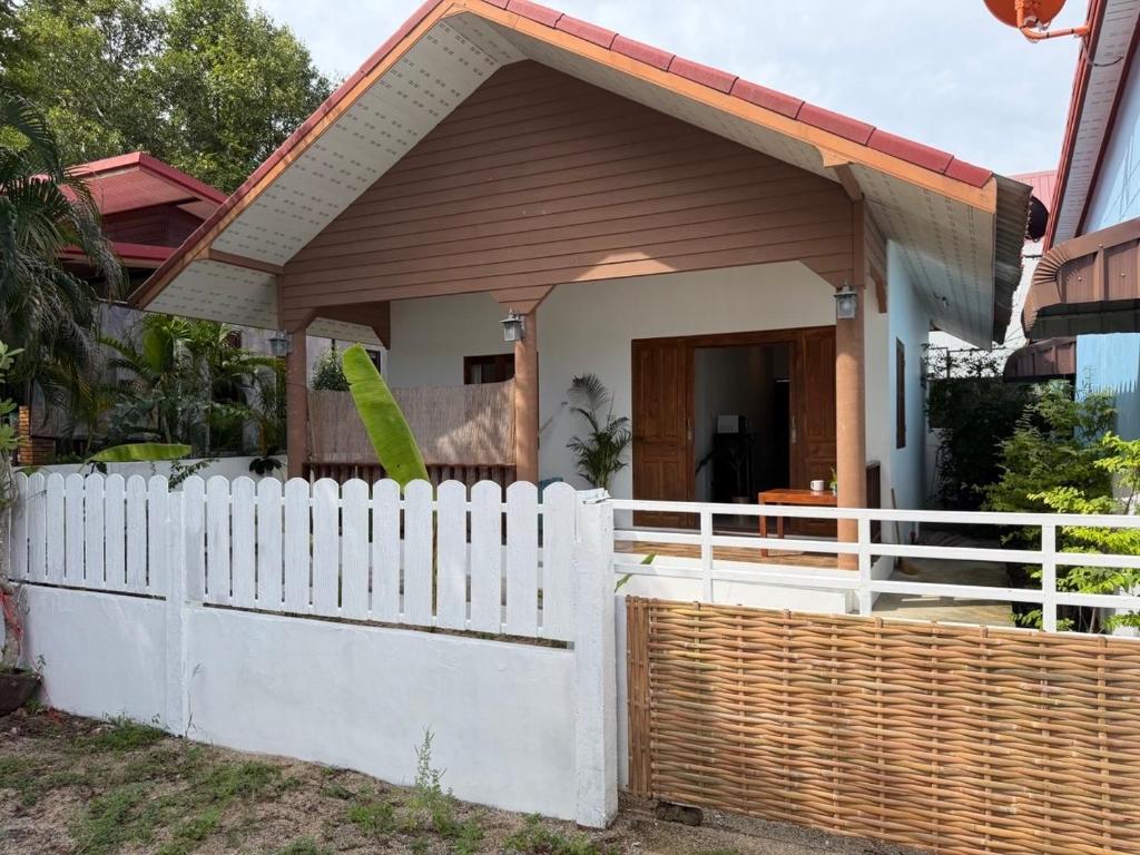 a white picket fence in front of a small house at Thong Sala Japandi Villa in Thong Sala